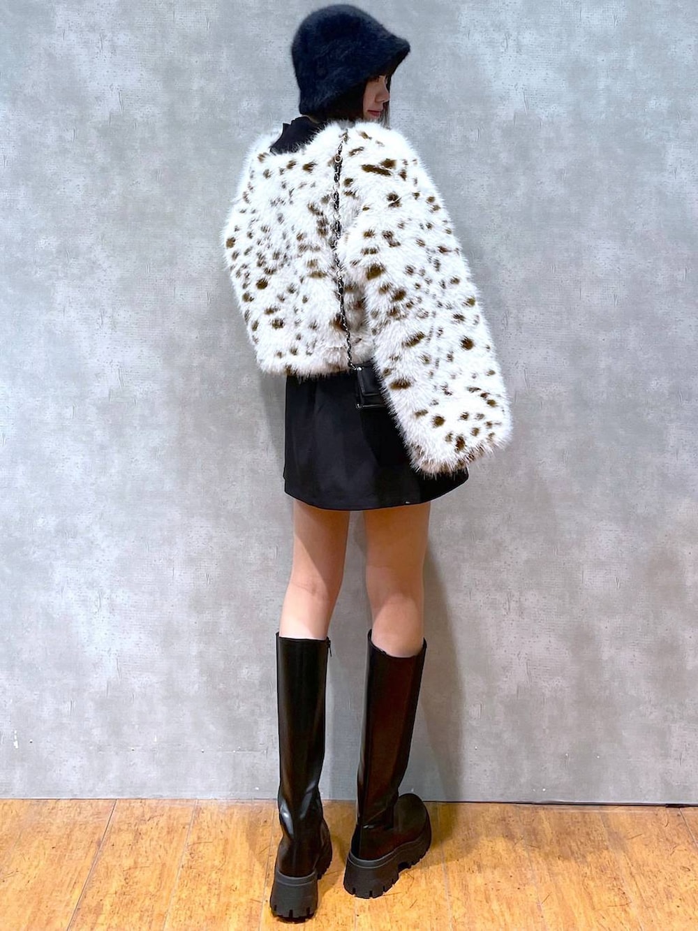 ブラック系のブーツ、ブラック系のニット/セーター、ブラウン系のブルゾンを着用したレディースの冬コーディネートの4枚目の写真