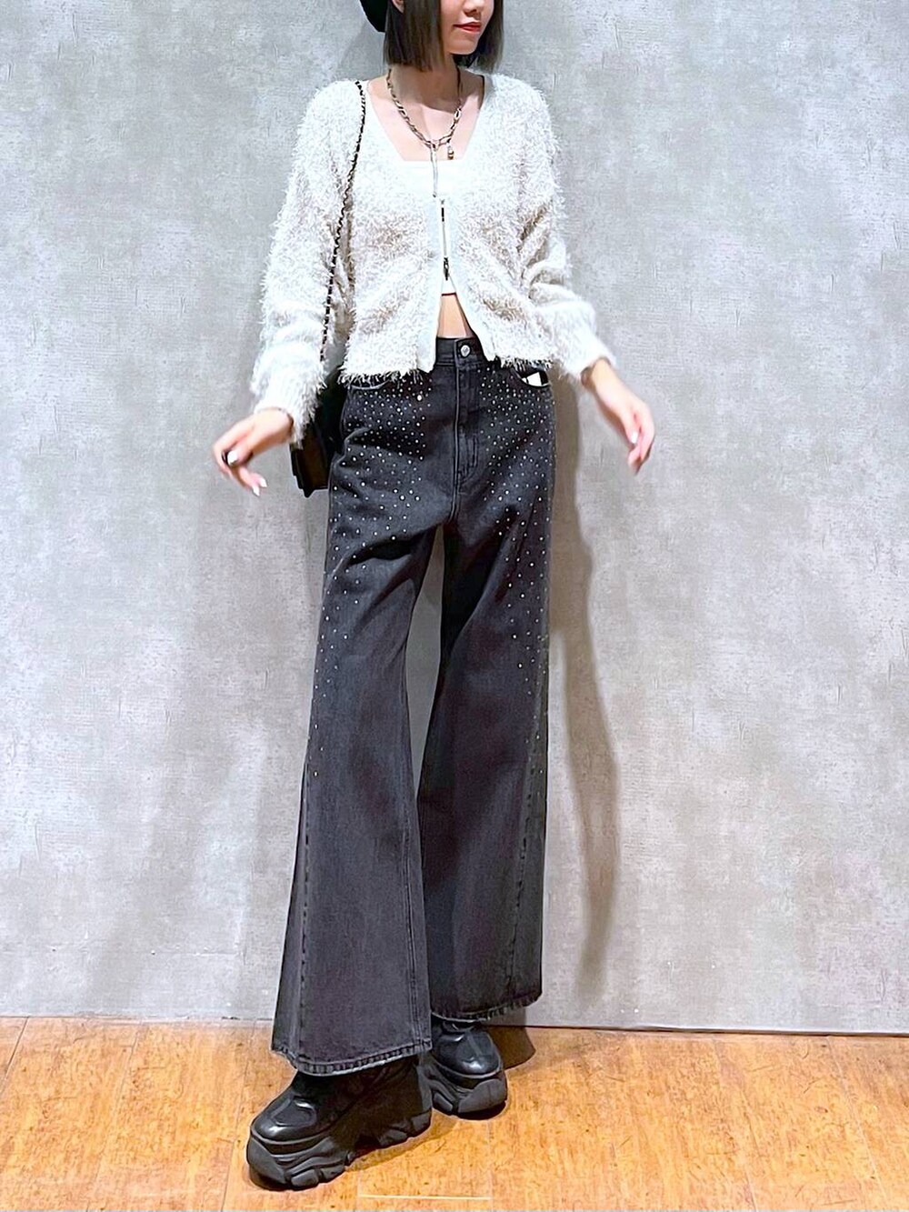 ブラック系のスニーカー、ブラック系のデニムパンツ、ブラック系のショルダーバッグを着用したレディースの秋コーディネートの10枚目の写真