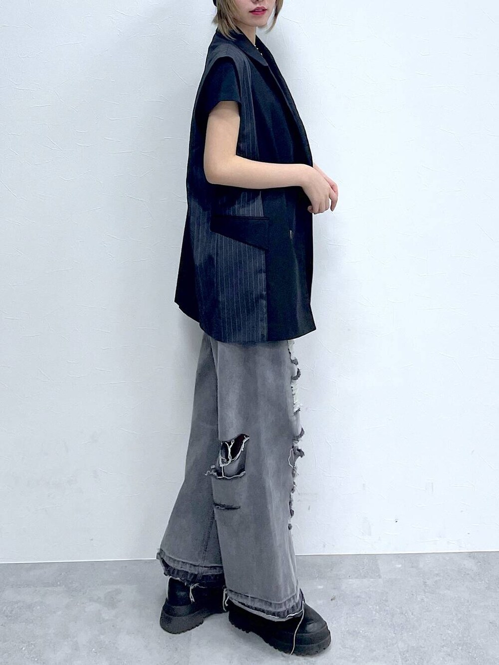 ブラック系のデニムパンツ、ブラック系のTシャツ/カットソー、ブラック系のブーツを着用したレディースの冬コーディネートの5枚目の写真