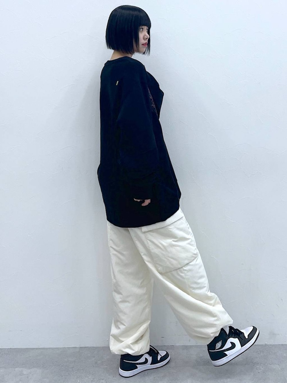ホワイト系のカーゴパンツ、ブラック系のスウェットを着用したレディースの冬コーディネートの2枚目の写真