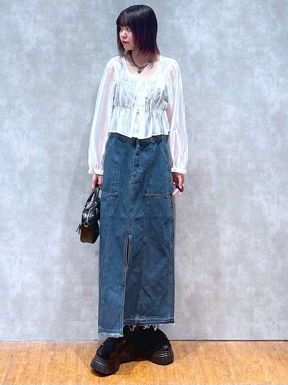 ブラック系のスニーカー、ホワイト系のシャツ/ブラウス、ブラック系のキャミソールを着用したレディースの春コーディネートの6枚目の写真