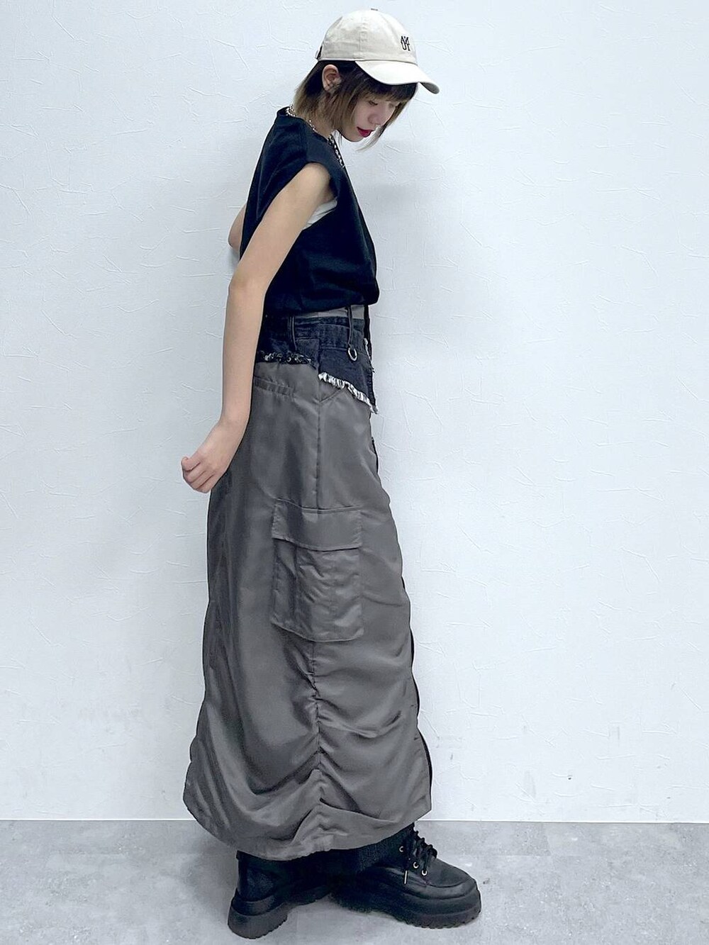 ブラック系のスラックス、ブラック系のTシャツ/カットソー、ブラック系のブーツを着用したレディースの春コーディネートの5枚目の写真