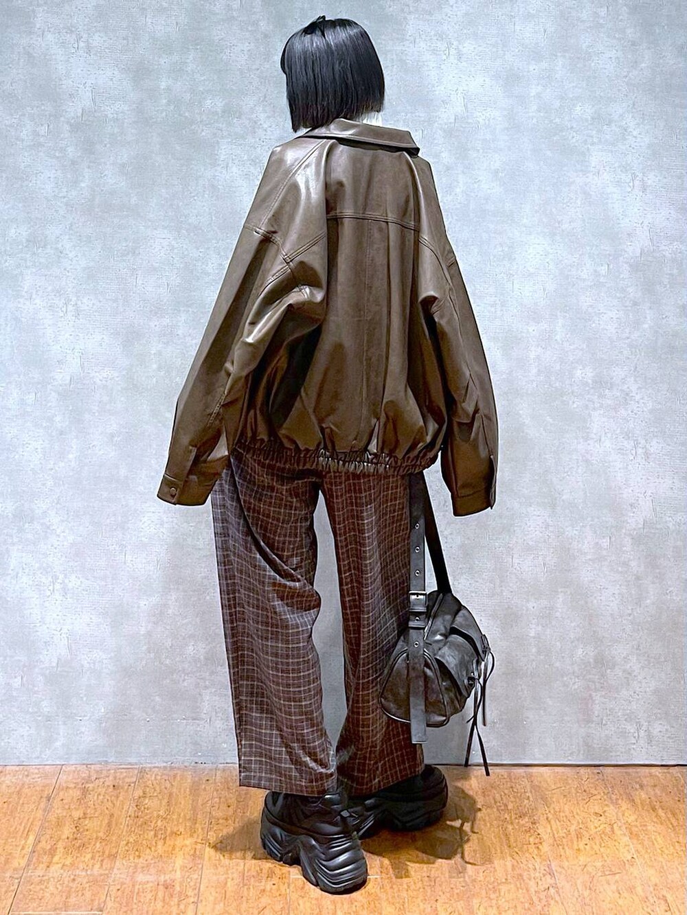 ブラック系のスニーカー、ブラック系のショルダーバッグ、ブラウン系のブルゾンを着用したレディースの秋コーディネートの7枚目の写真