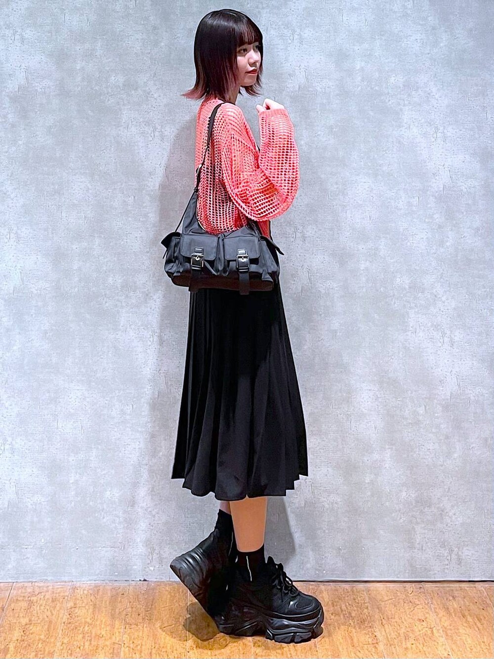 ブラック系のショルダーバッグ、ピンク系のカーディガン/ボレロ、ブラック系のキャミソールを着用したレディースの春コーディネートの5枚目の写真