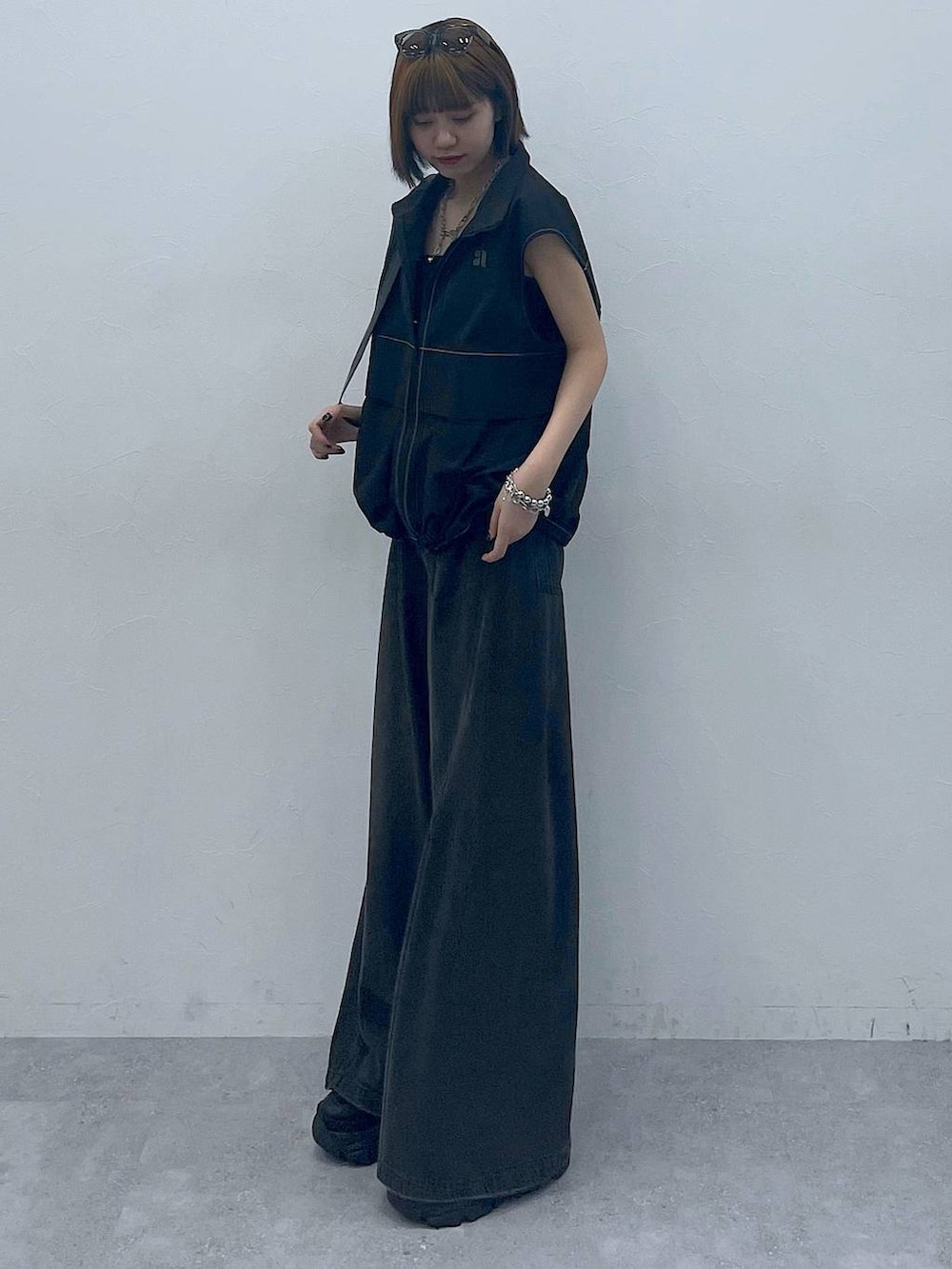 ブラック系のスニーカー、ブラック系のショルダーバッグ、ブラック系のデニムパンツを着用したレディースの夏コーディネートの4枚目の写真