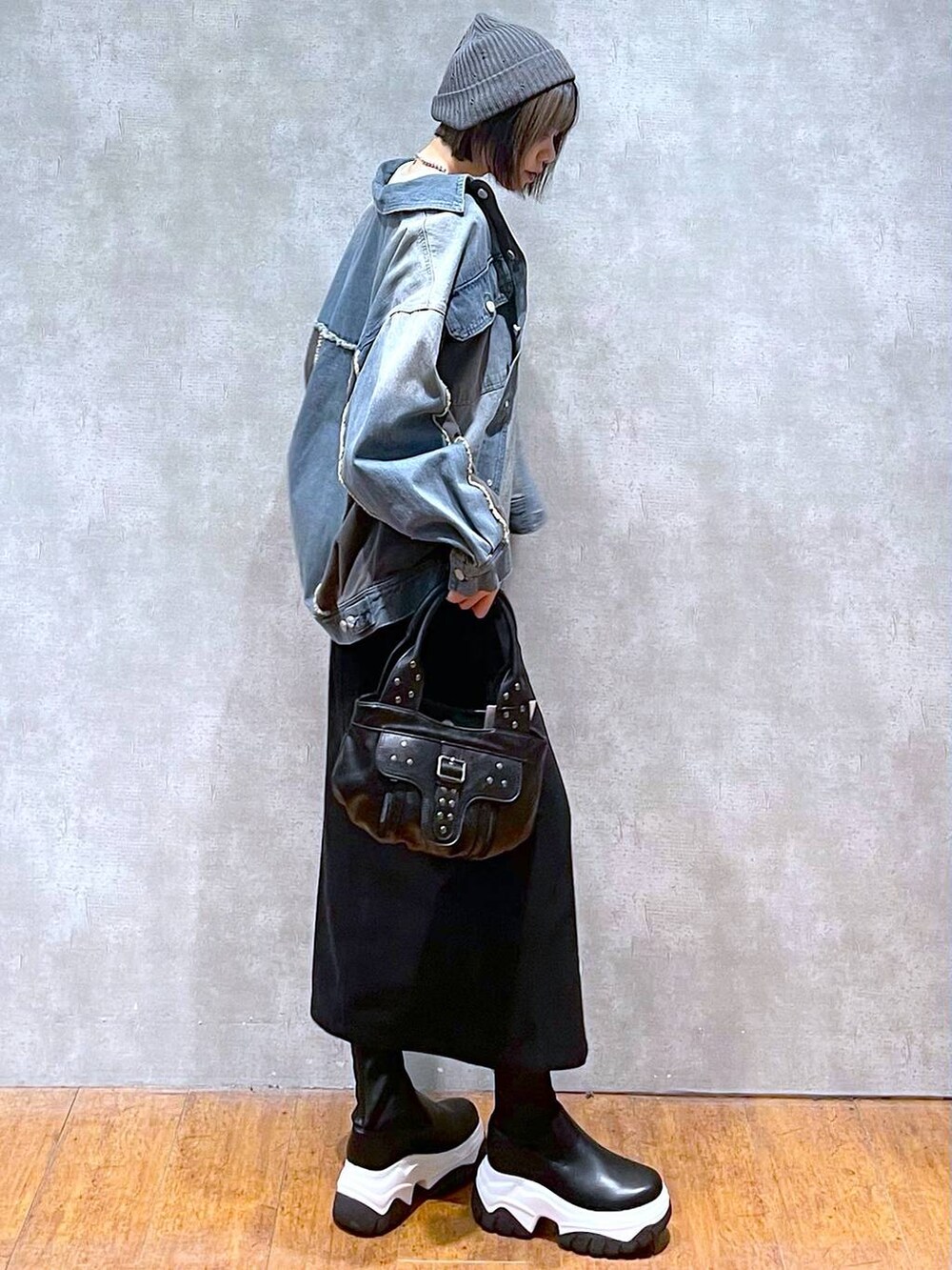 ブルー系のブルゾン、ブラック系のハンドバッグ、ホワイト系のTシャツ/カットソーを着用したレディースの秋コーディネートの3枚目の写真
