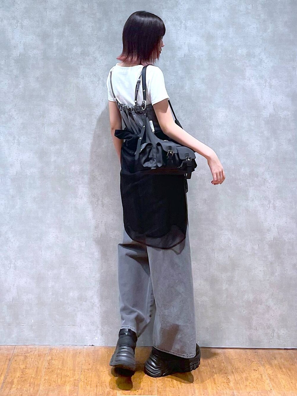 ブラック系のショルダーバッグ、ブラック系のサロペット/オーバーオール、ブラック系のスニーカーを着用したレディースの春コーディネートの6枚目の写真