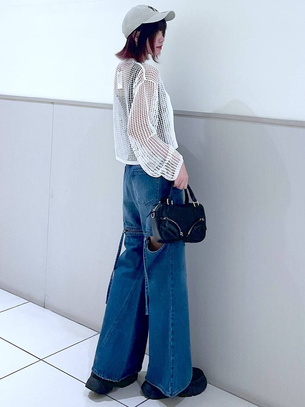 ホワイト系のカーディガン/ボレロ、ブラック系のタンクトップ、ブルー系のデニムパンツを着用したレディースの春コーディネートの6枚目の写真