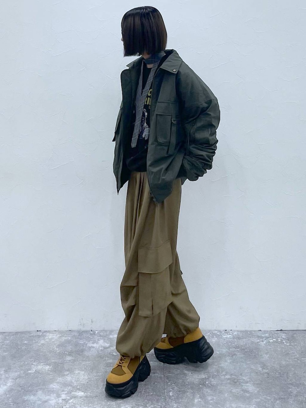 グレー系のネクタイ、ブラウン系のブーツ、グリーン系のブルゾンを着用したレディースの秋コーディネートの6枚目の写真