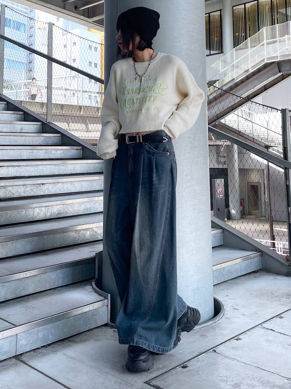ブラック系のスニーカー、ブルー系のデニムパンツ、ホワイト系のニット/セーターを着用したレディースの秋コーディネートの7枚目の写真