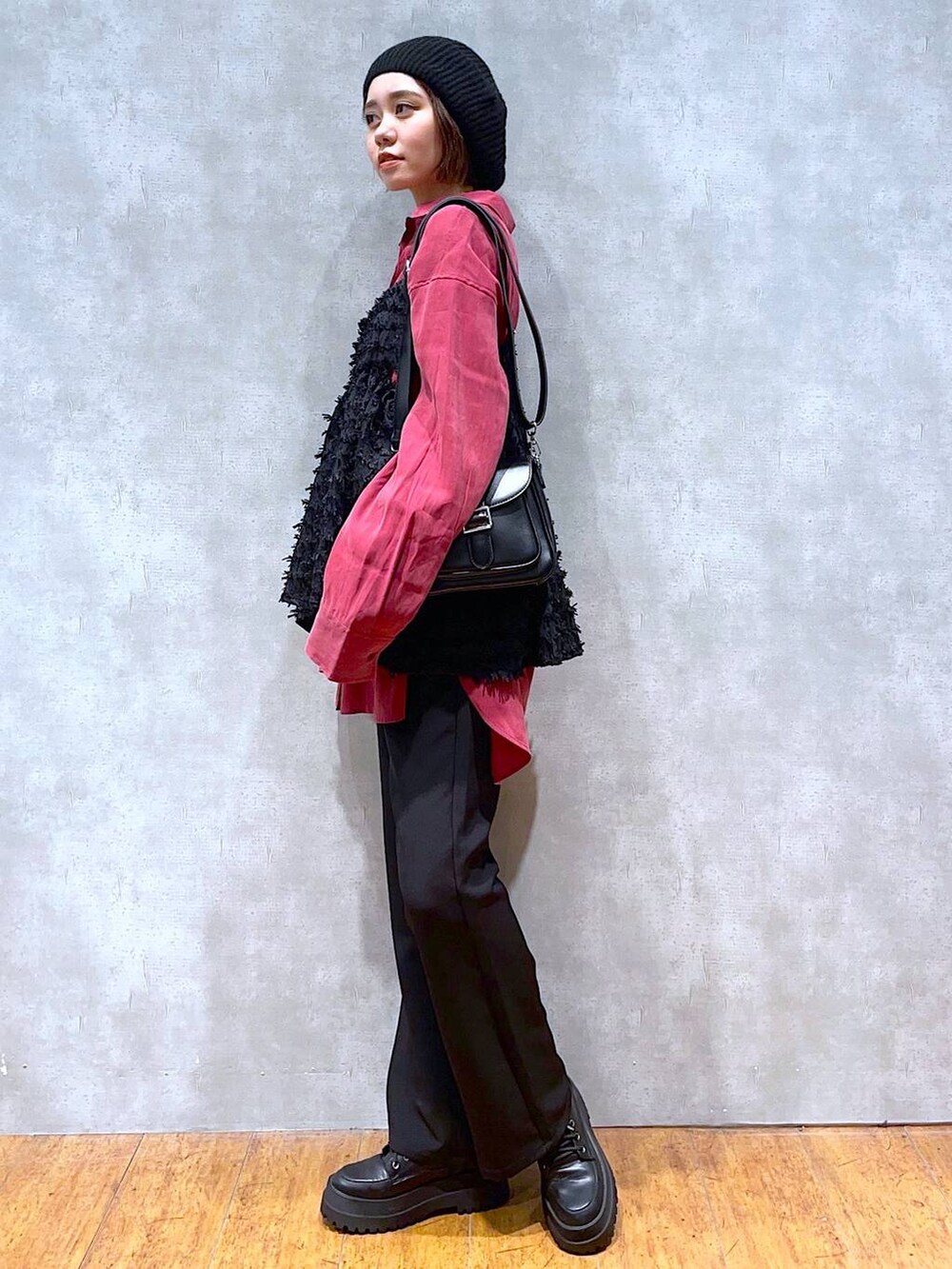 ブラック系のブーツ、ブラック系のスラックス、ブラック系のショルダーバッグを着用したレディースの秋コーディネートの2枚目の写真