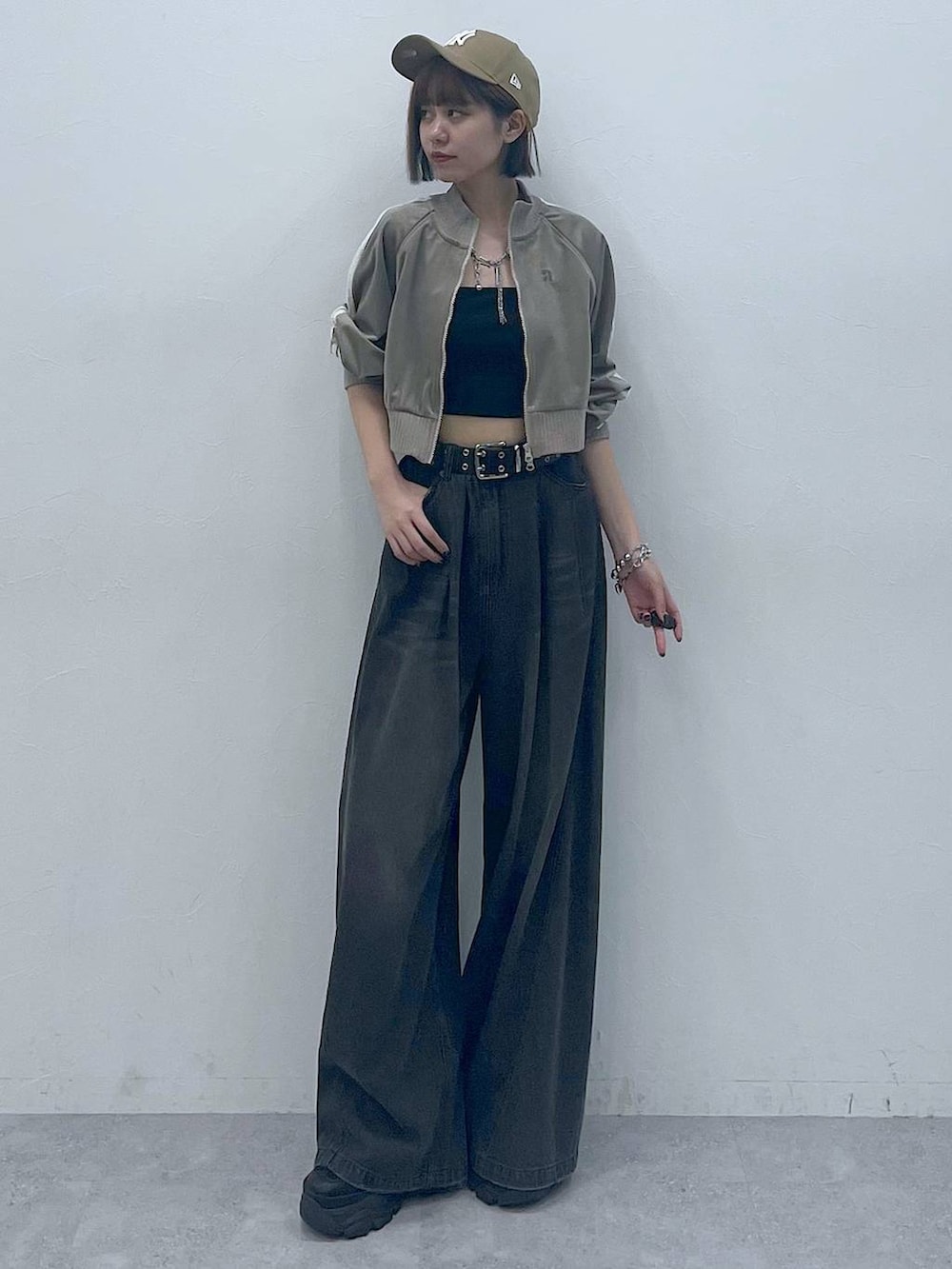 ブラック系のスニーカー、ブラック系のキャミソール、ブラック系のデニムパンツを着用したレディースの秋コーディネートの4枚目の写真