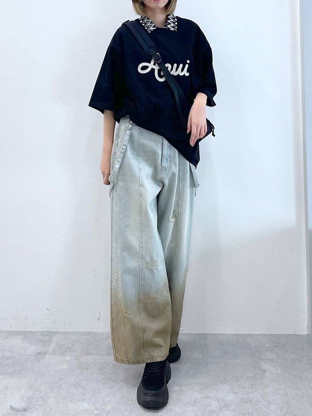 ブラック系のTシャツ/カットソー、ブラック系のボディバッグ/ウエストポーチ、ブラック系のブーツを着用したレディースの春コーディネートの6枚目の写真