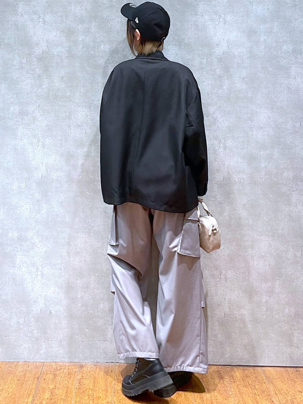 ブラック系のテーラードジャケット、ホワイト系のTシャツ/カットソー、ブラック系のブーツを着用したレディースの冬コーディネートの6枚目の写真