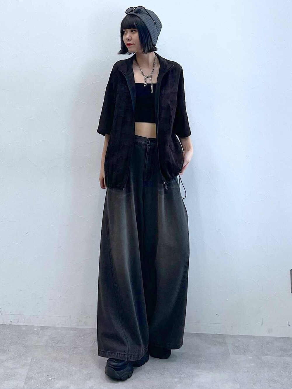 ブラック系のスニーカー、ブラック系のデニムパンツ、グレー系のシャツ/ブラウスを着用したレディースの夏コーディネートの2枚目の写真