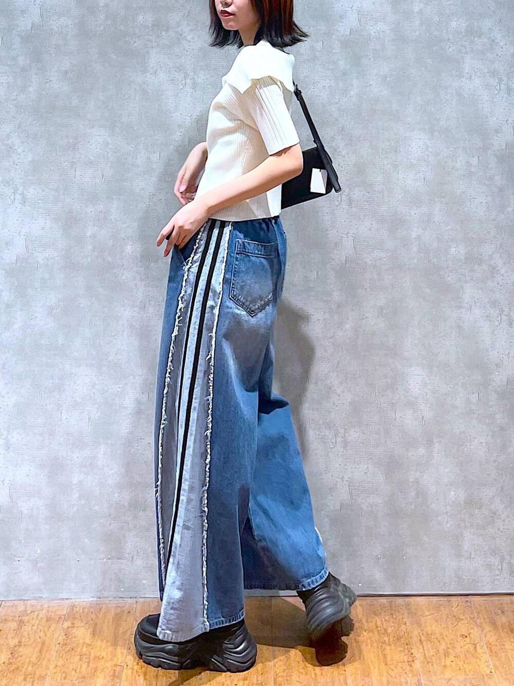 ブラック系のスニーカー、ホワイト系のニット/セーター、ホワイト系のキャミソールを着用したレディースの夏コーディネートの6枚目の写真