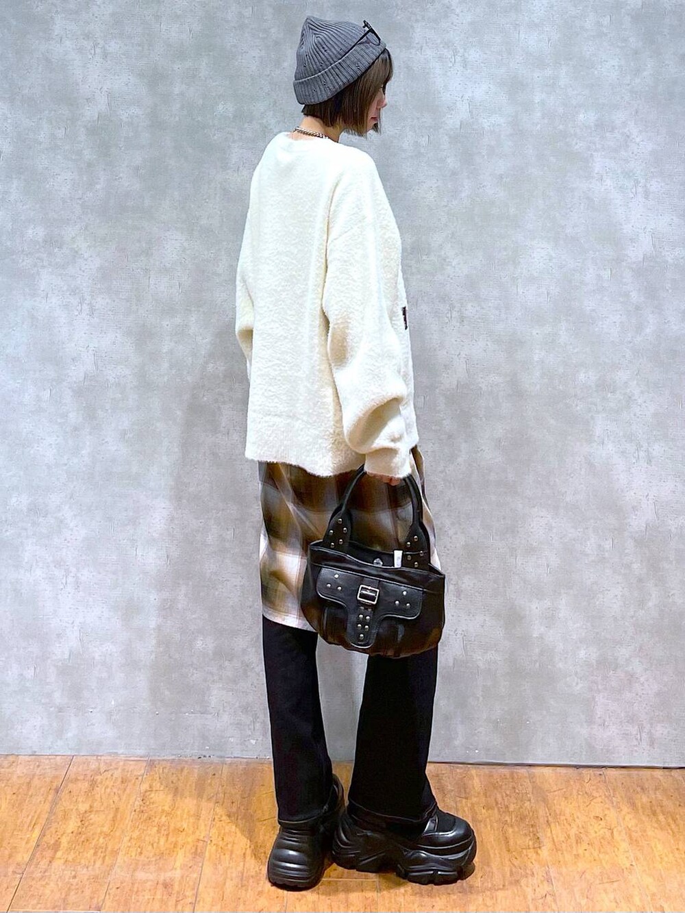 ブラック系のブーツ、イエロー系のシャツ/ブラウス、ホワイト系のニット/セーターを着用したレディースの秋コーディネートの4枚目の写真