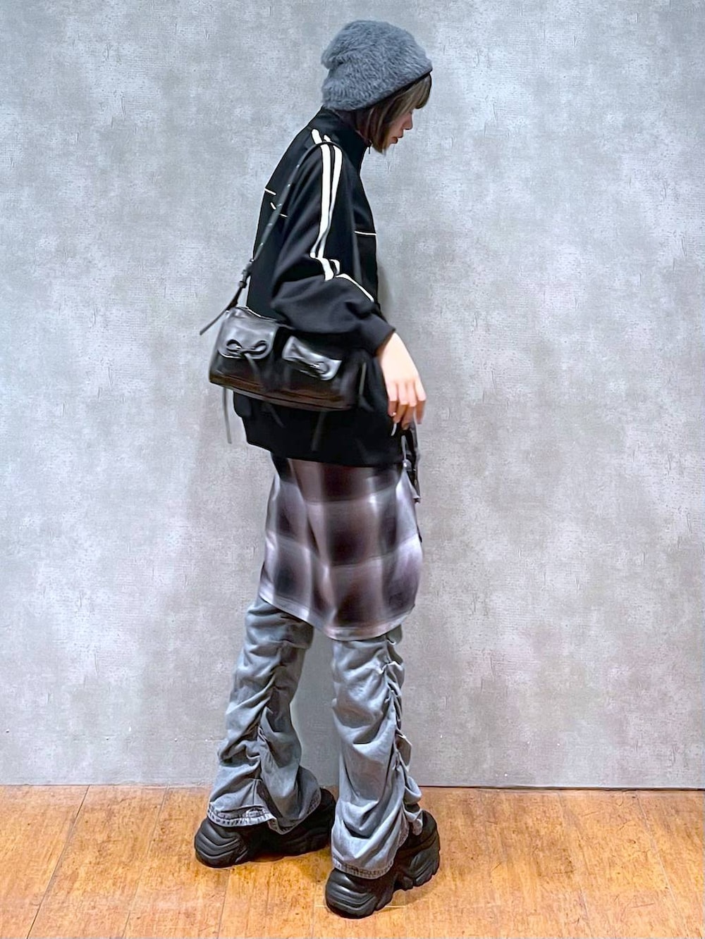 ブラック系のスニーカー、ブラック系のショルダーバッグ、ブルー系のデニムパンツを着用したレディースの秋コーディネートの8枚目の写真