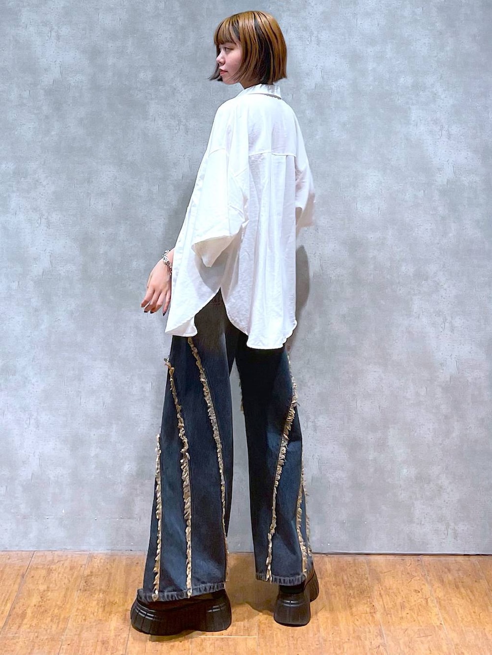 ブラック系のスニーカー、ブラック系のキャミソール、ホワイト系のシャツ/ブラウスを着用したレディースの夏コーディネートの6枚目の写真