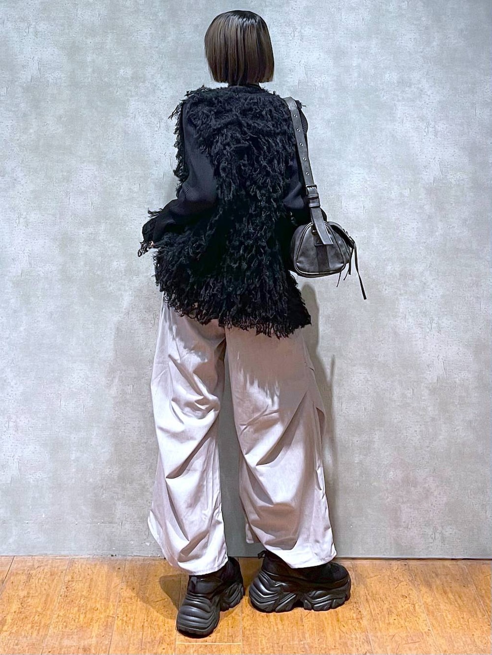 ブラック系のスニーカー、ブラック系のショルダーバッグ、グレー系のその他パンツを着用したレディースの秋コーディネートの8枚目の写真