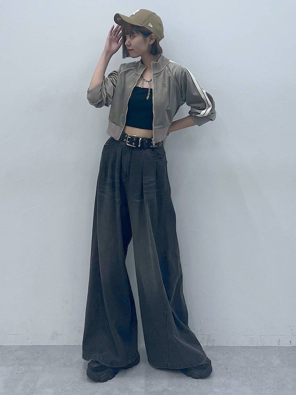 ブラック系のスニーカー、ブラック系のキャミソール、ブラック系のデニムパンツを着用したレディースの秋コーディネートの3枚目の写真