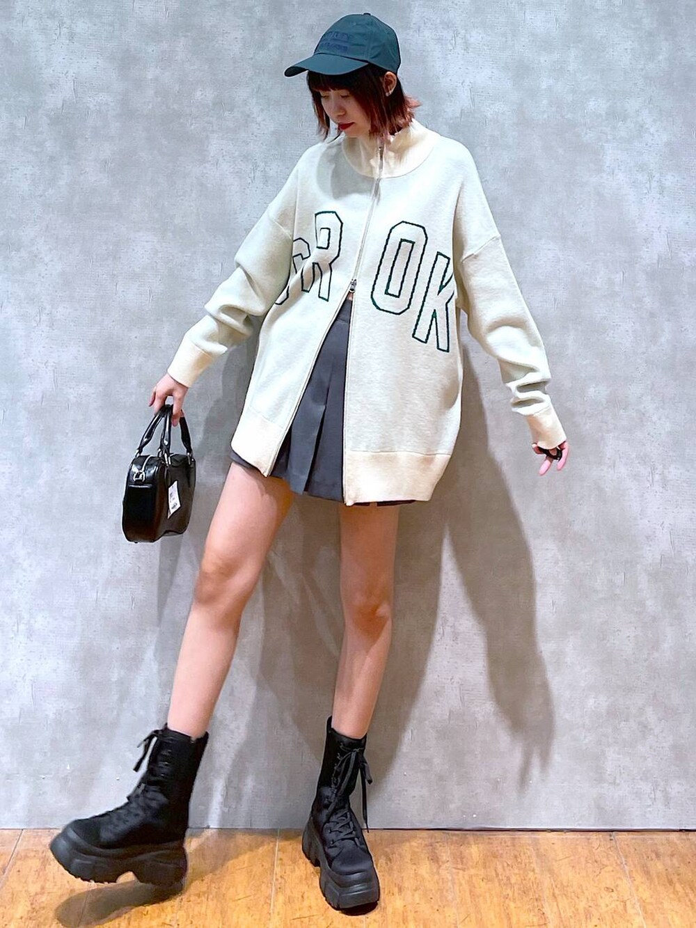 ベージュ系のニット/セーター、グレー系のその他パンツ、ブラック系のブーツを着用したレディースの春コーディネートの4枚目の写真