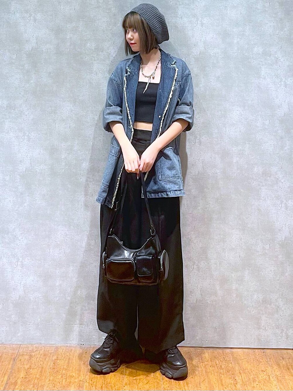 ブラック系のスニーカー、ブルー系のテーラードジャケット、ブラック系のキャミソールを着用したレディースの秋コーディネートの7枚目の写真