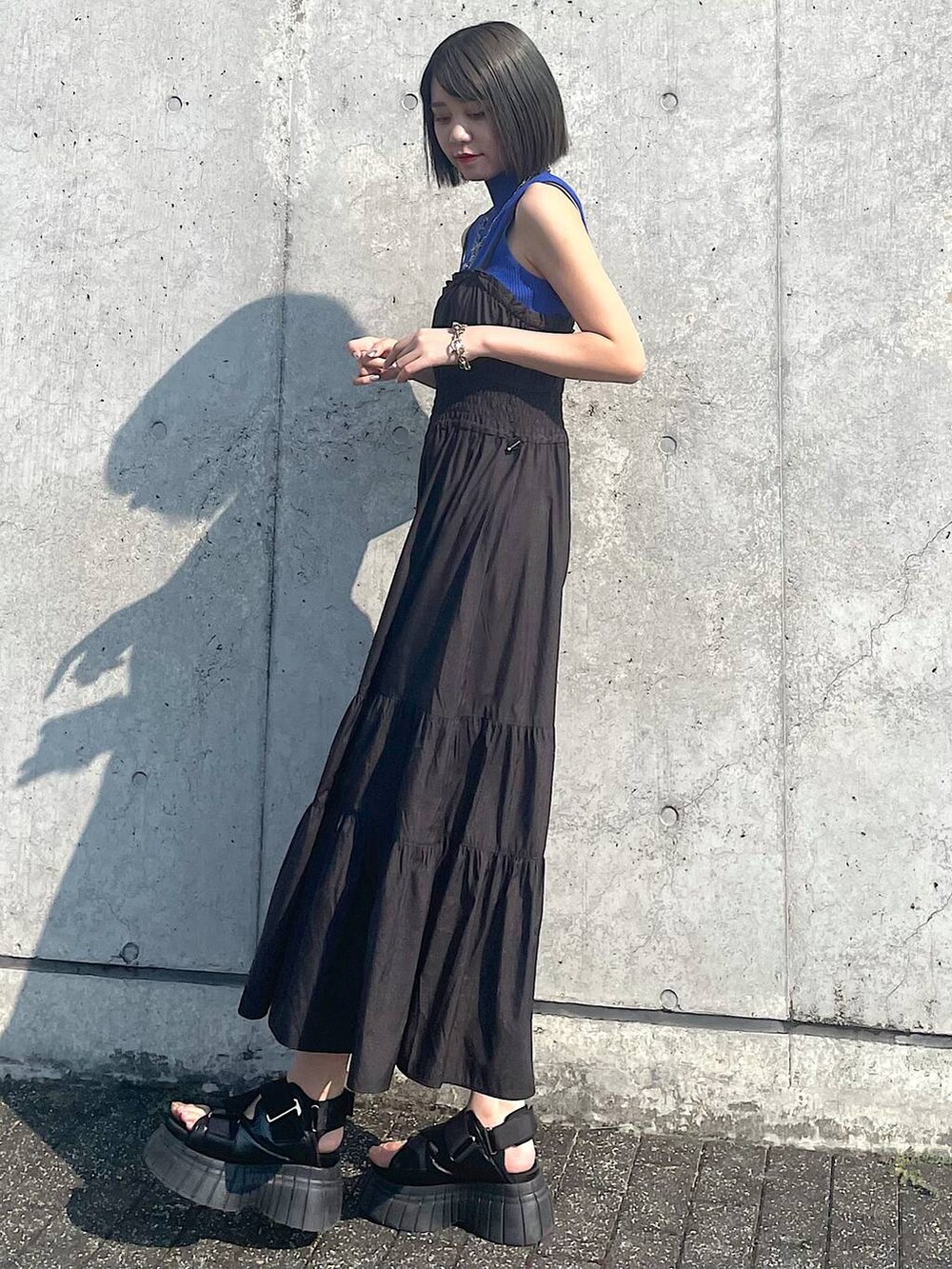 ブラック系のスニーカー、ブラック系のワンピース、シルバー系のネックレスを着用したレディースの夏コーディネートの4枚目の写真
