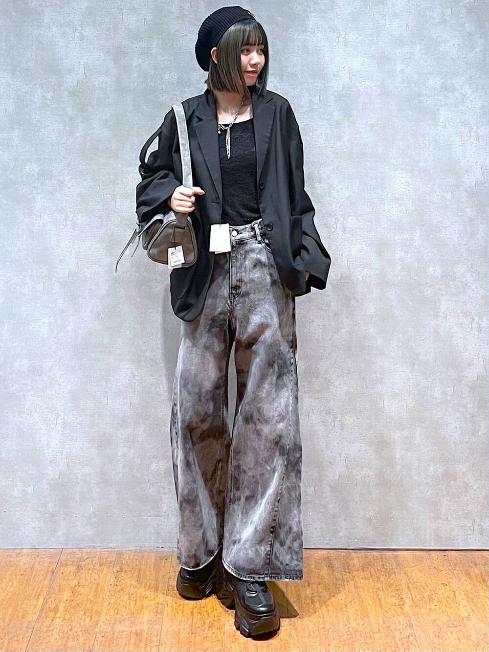 ブラック系のスニーカー、グレー系のショルダーバッグ、ブラック系のデニムパンツを着用したレディースの秋コーディネートの9枚目の写真