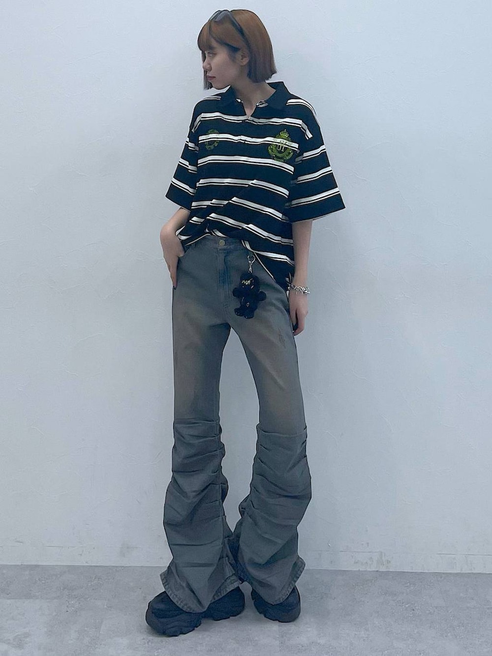 ブラック系のスニーカー、ブラック系のTシャツ/カットソー、ブルー系のデニムパンツを着用したレディースの夏コーディネートの3枚目の写真