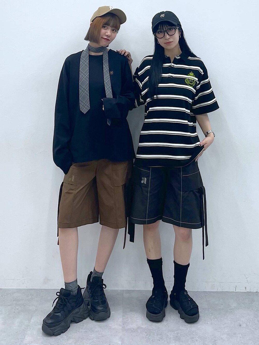 ブラック系のスニーカー、グレー系のネクタイ、ブラウン系のカーゴパンツを着用したレディースの夏コーディネートの2枚目の写真