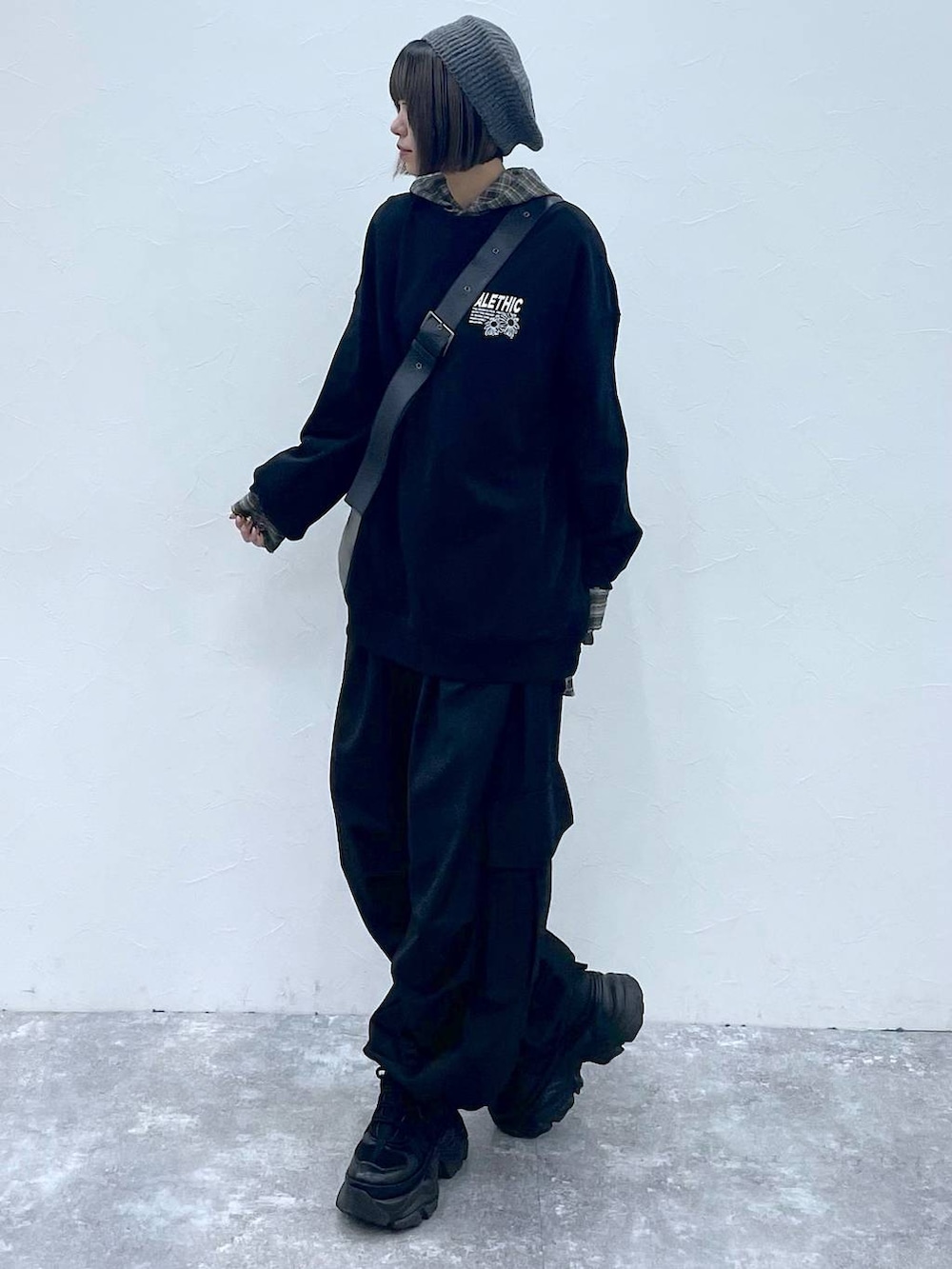 ブラック系のスニーカー、ブラック系のスウェット、シルバー系のトートバッグを着用したレディースの秋コーディネートの2枚目の写真