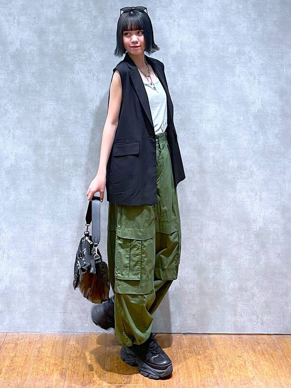 ブラック系のスニーカー、グリーン系のその他パンツ、ブラック系のショルダーバッグを着用したレディースの夏コーディネートの6枚目の写真