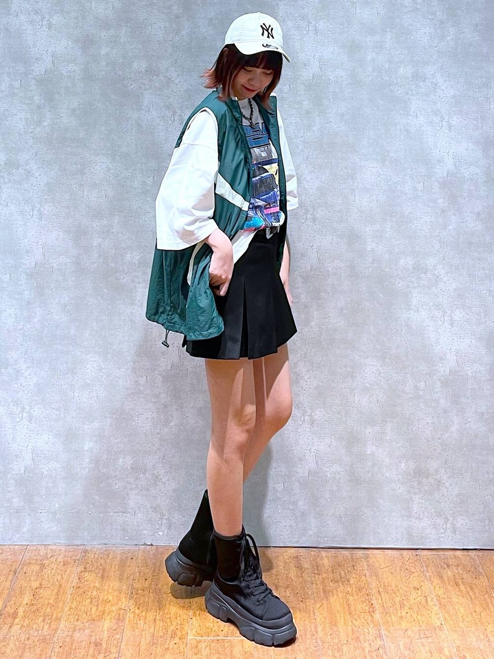 グリーン系のベスト、ホワイト系のTシャツ/カットソー、ブラック系のその他パンツを着用したレディースの春コーディネートの4枚目の写真