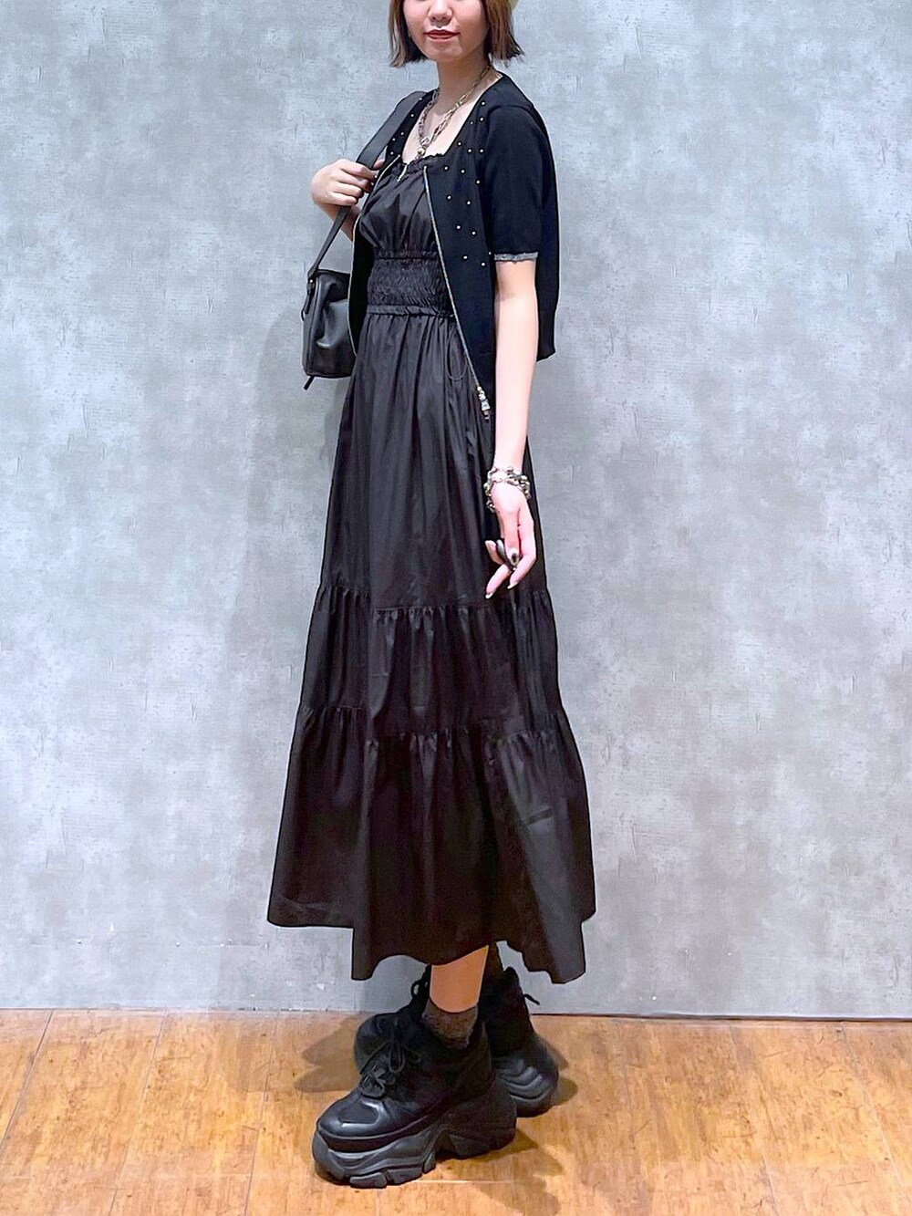 ブラック系のスニーカー、ブラック系のワンピース、ブラック系のショルダーバッグを着用したレディースの夏コーディネートの6枚目の写真