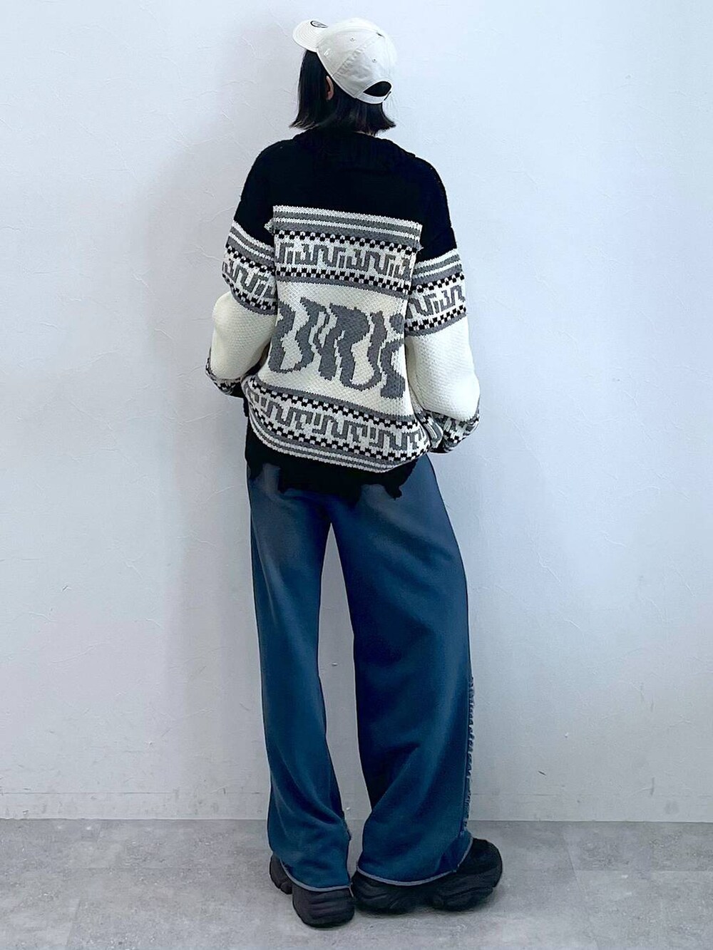 ブラック系のスニーカー、ブルー系のスウェットパンツ、ブラック系のTシャツ/カットソーを着用したレディースの秋コーディネートの4枚目の写真