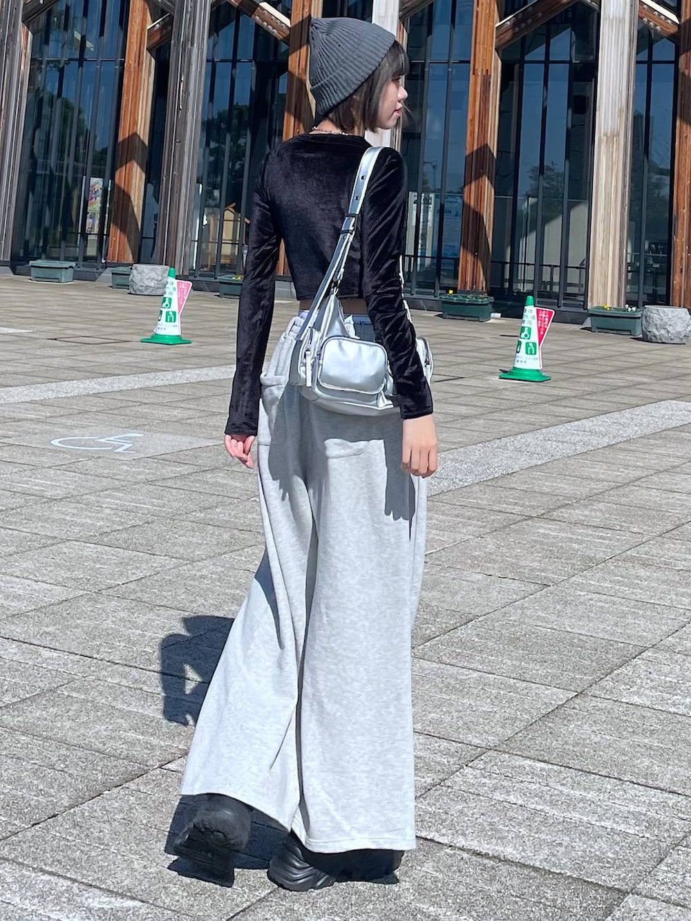 ブラック系のスニーカー、シルバー系のショルダーバッグ、ブラック系のTシャツ/カットソーを着用したレディースの秋コーディネートの4枚目の写真