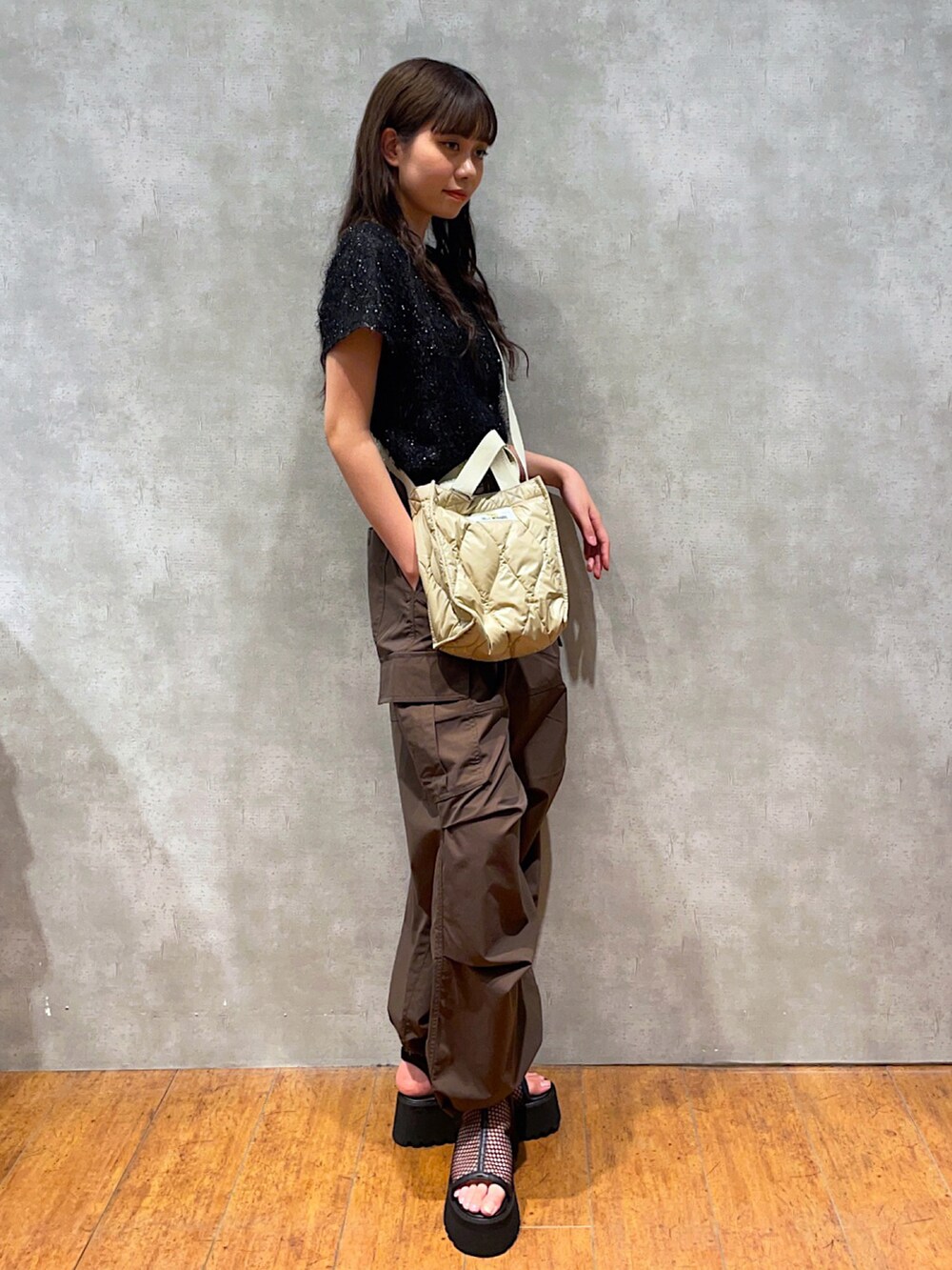 ブラック系のTシャツ/カットソー、ベージュ系のショルダーバッグ、ブラウン系のスラックスを着用したレディースの夏コーディネートの2枚目の写真