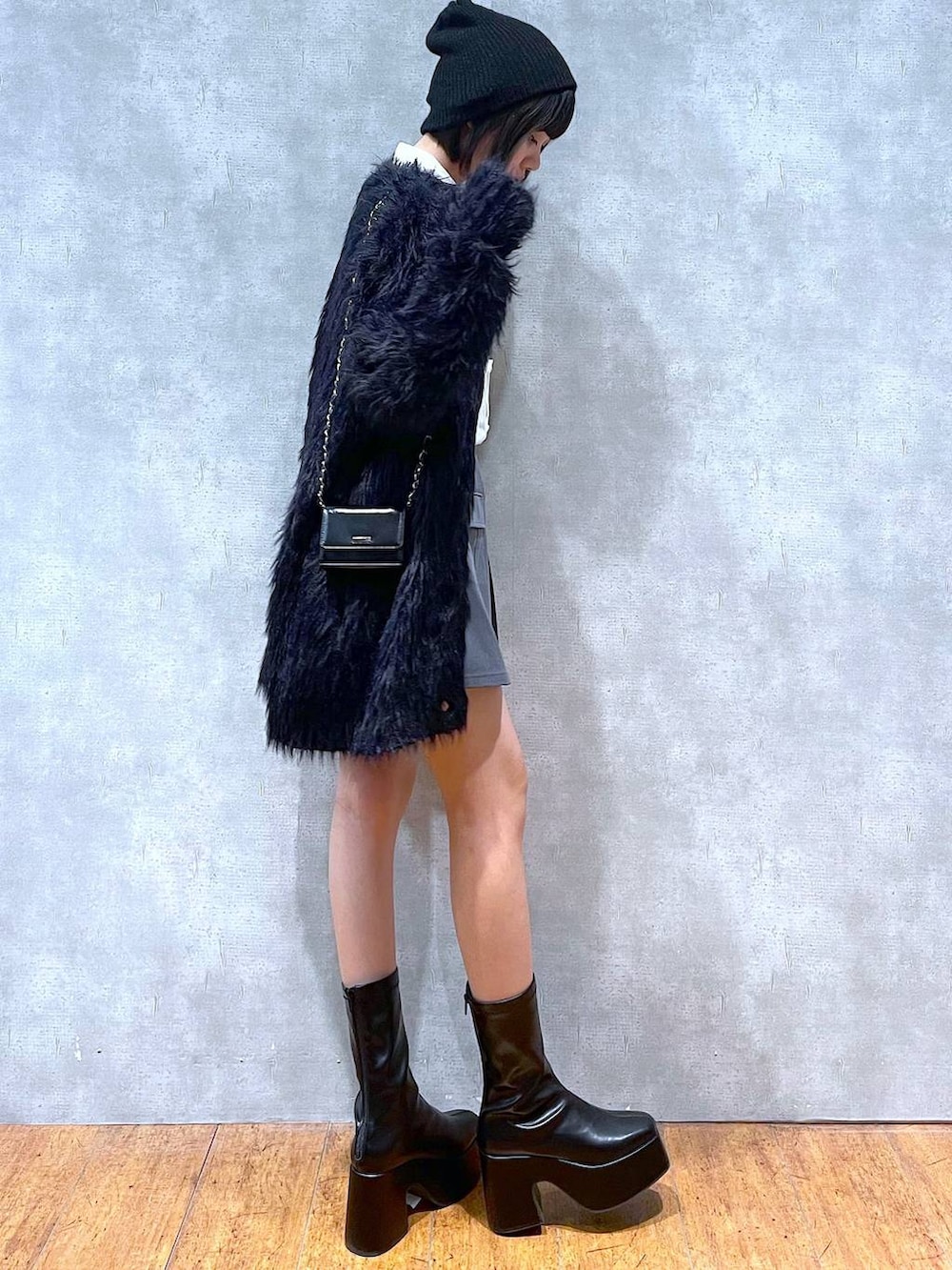 ブラック系のカーディガン/ボレロ、ブラック系のブーツ、ブラック系のショルダーバッグを着用したレディースの冬コーディネートの2枚目の写真