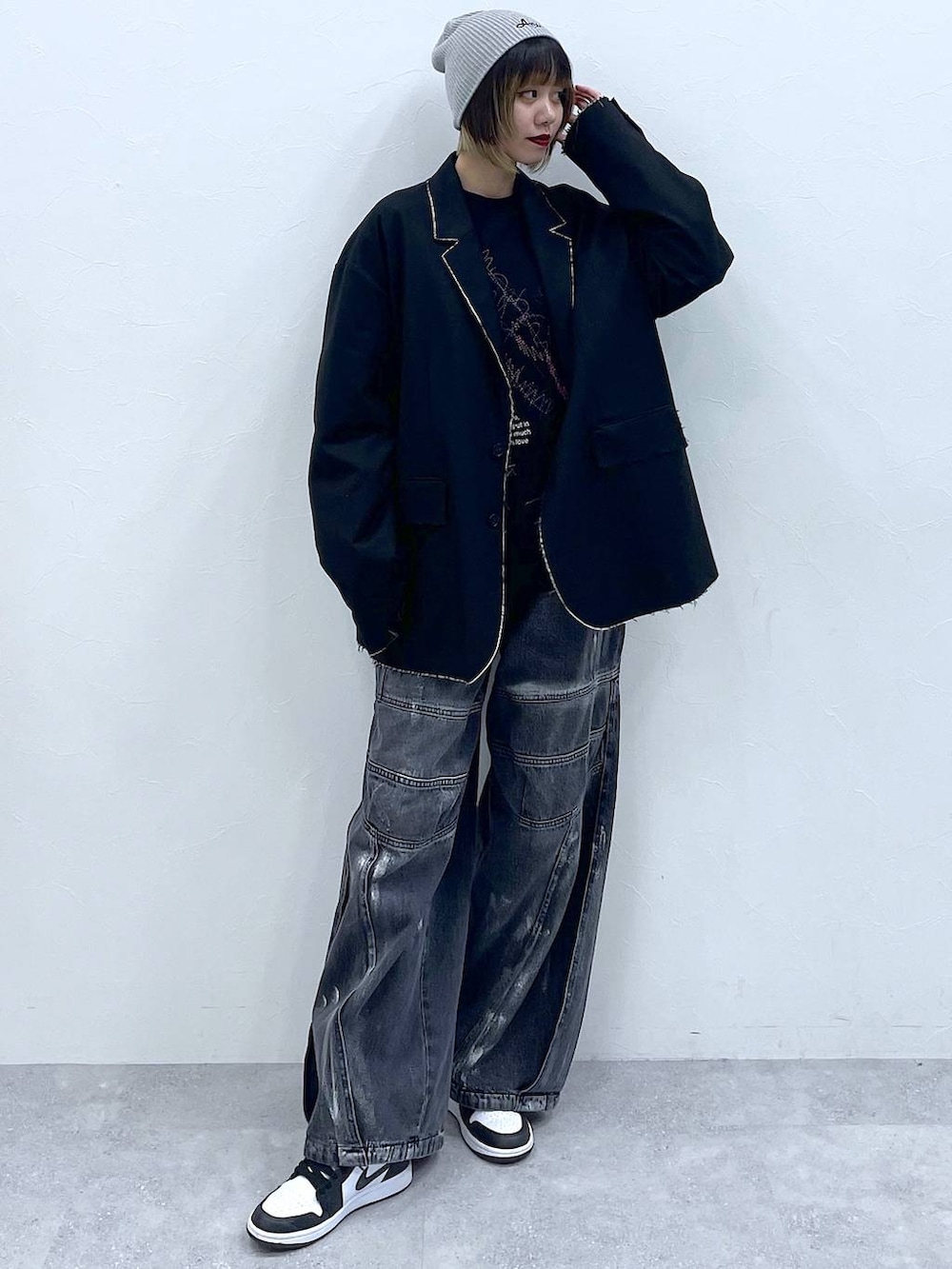 ブラック系のテーラードジャケット、ブラック系のデニムパンツ、ブラック系のスウェットを着用したレディースの冬コーディネートの3枚目の写真