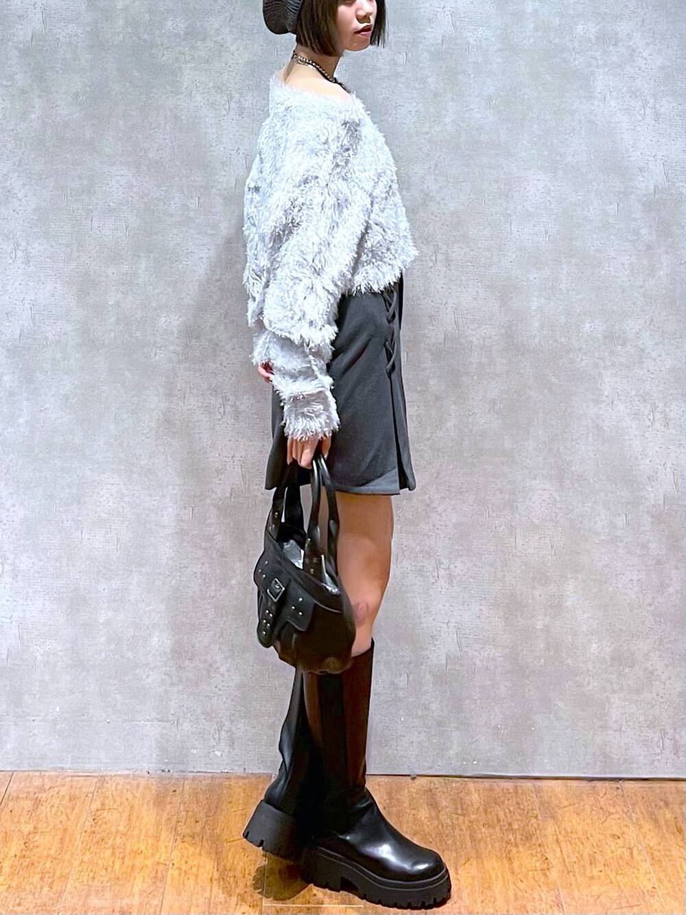 グレー系のその他パンツ、ブラック系のハンドバッグ、ブラック系のブーツを着用したレディースの秋コーディネートの7枚目の写真