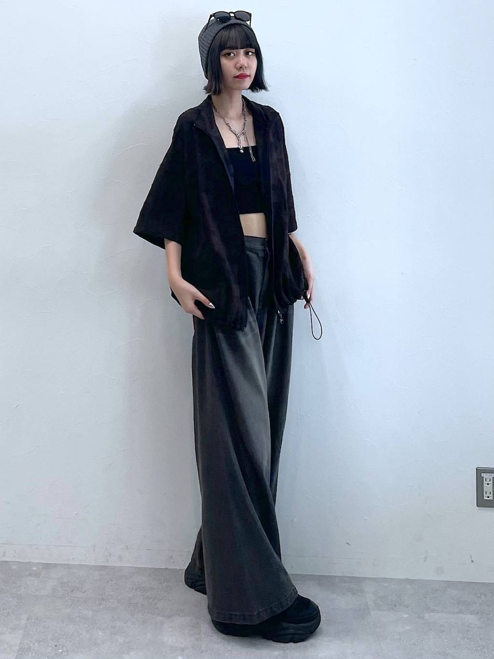 ブラック系のスニーカー、ブラック系のデニムパンツ、グレー系のシャツ/ブラウスを着用したレディースの夏コーディネートの3枚目の写真