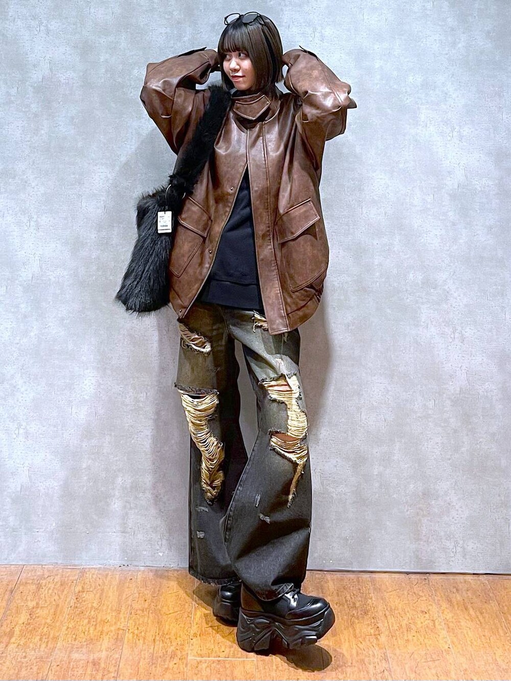 ブラウン系のブルゾン、ブラック系のブーツ、グレー系のスウェットを着用したレディースの秋コーディネートの2枚目の写真