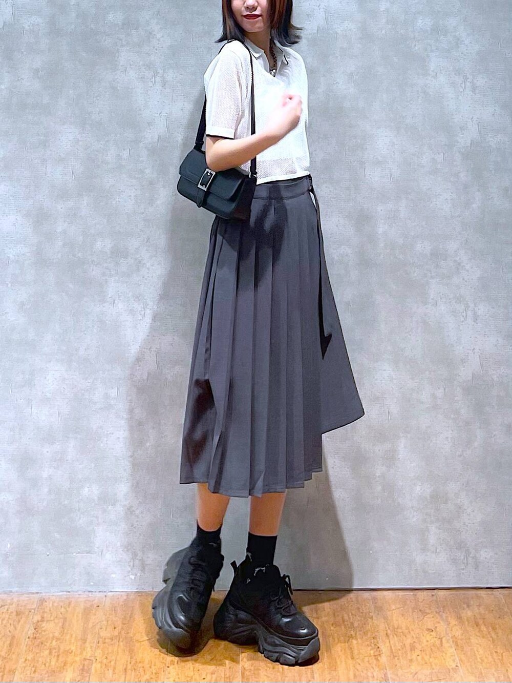 ブラック系のスニーカー、グレー系のスカート、ホワイト系のキャミソールを着用したレディースの夏コーディネートの2枚目の写真