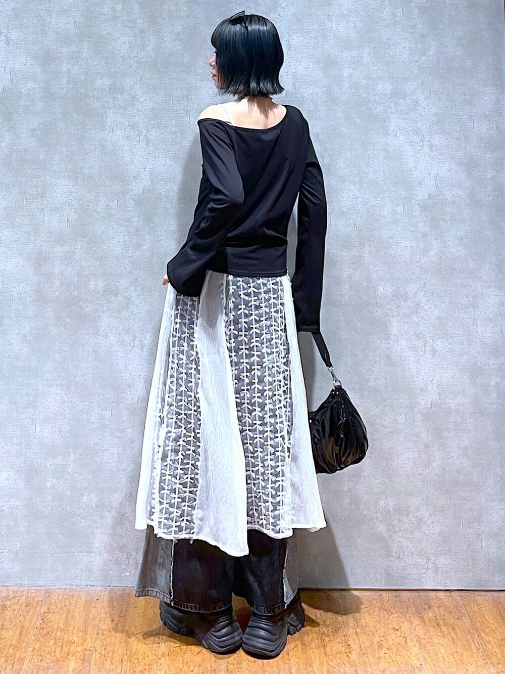 ブラック系のスニーカー、ブラック系のデニムパンツ、ブラック系のショルダーバッグを着用したレディースの夏コーディネートの6枚目の写真