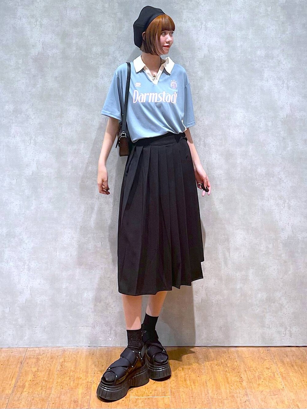 ブラック系のスニーカー、ブラック系のスカート、ブラック系のハンドバッグを着用したレディースの夏コーディネートの3枚目の写真