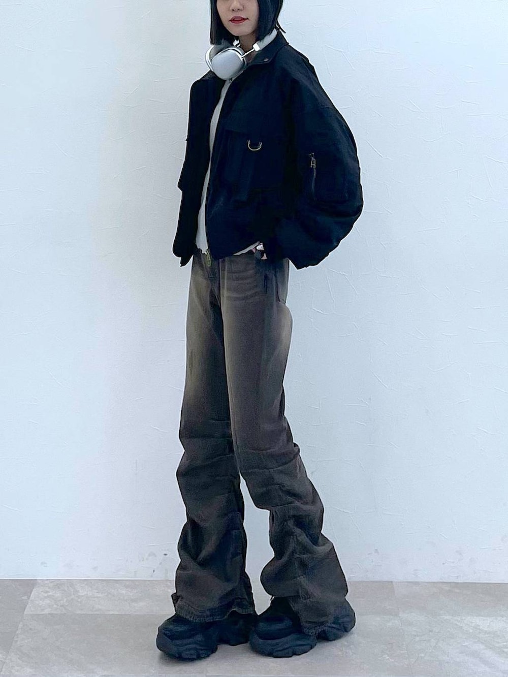 ブラック系のスニーカー、ブラック系のデニムパンツ、グレー系のTシャツ/カットソーを着用したレディースの秋コーディネートの5枚目の写真