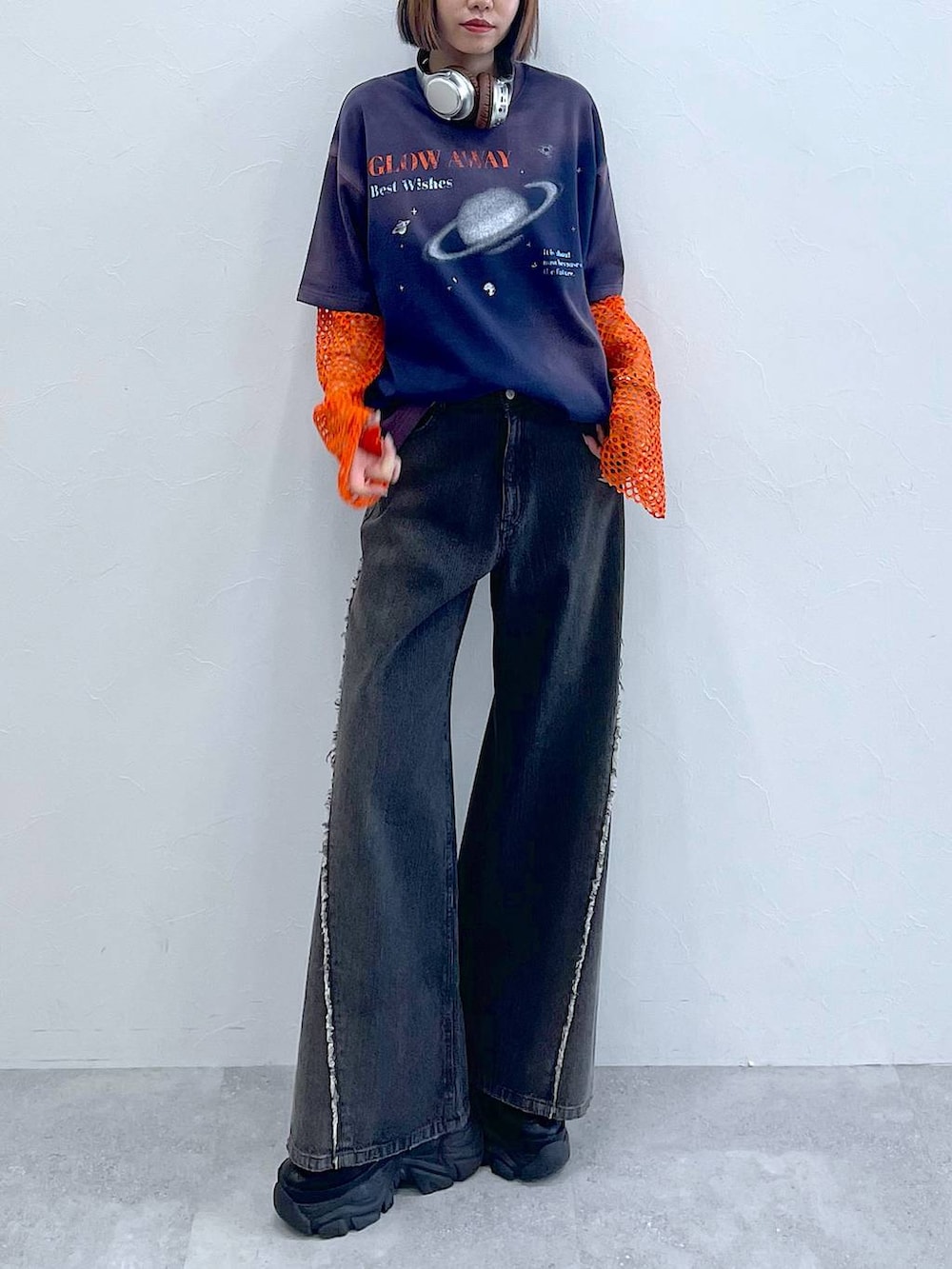 ブラック系のスニーカー、オレンジ系のTシャツ/カットソー、ブラック系のデニムパンツを着用したレディースの夏コーディネートの5枚目の写真