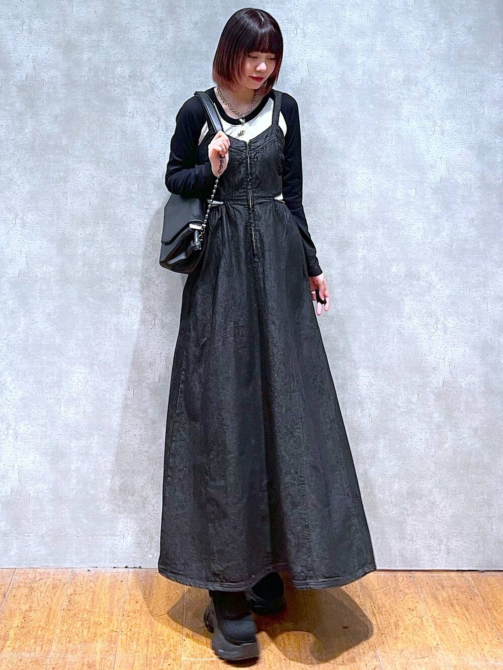 ブラック系のショルダーバッグ、ホワイト系のTシャツ/カットソー、ブラック系のワンピースを着用したレディースの春コーディネートの6枚目の写真