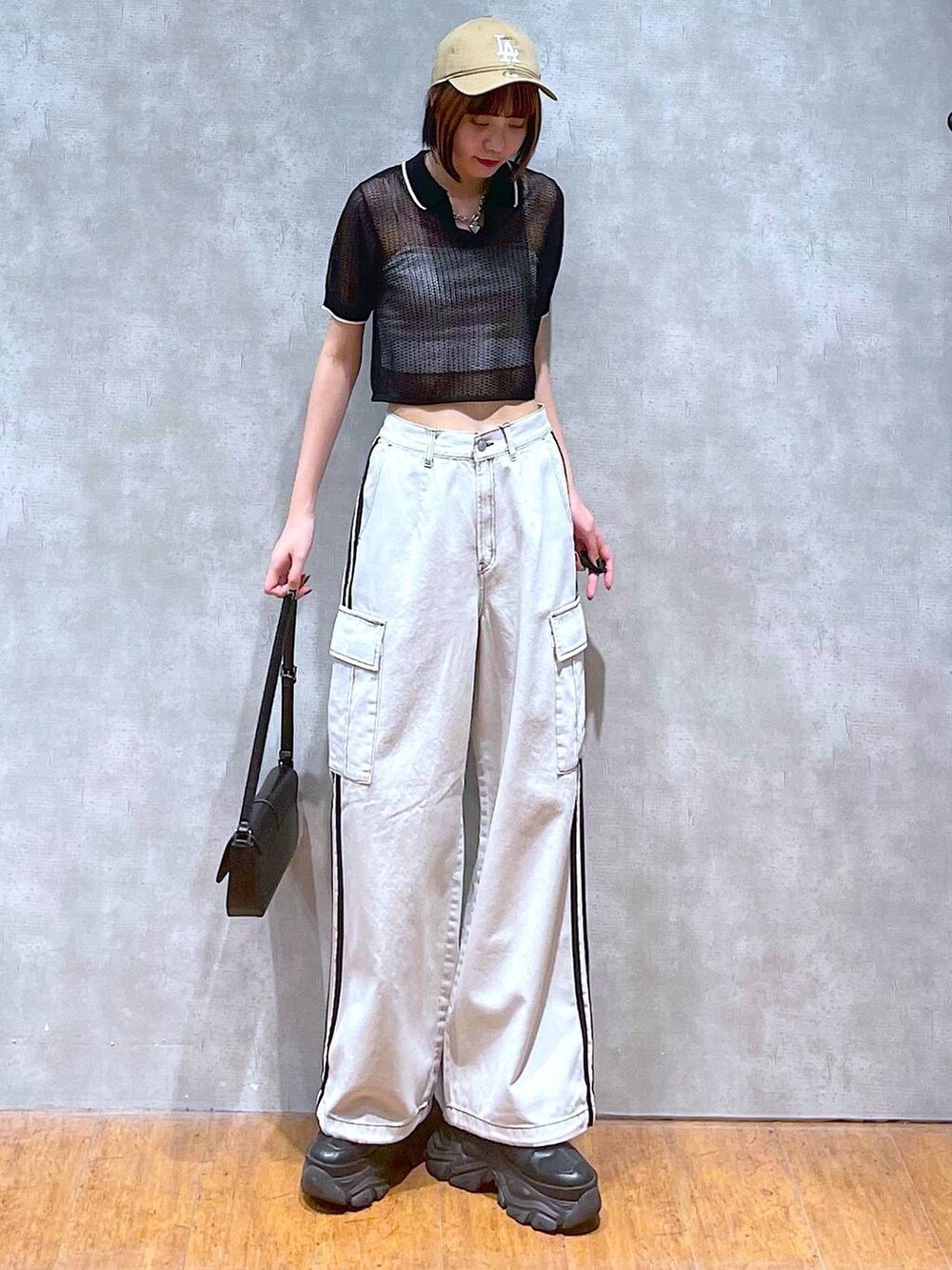 ブラック系のスニーカー、ホワイト系のデニムパンツ、ホワイト系のキャミソールを着用したレディースの夏コーディネートの3枚目の写真